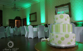 Green and white wedding cake with matching green up lighting around an impressive hall at Alfreton hall