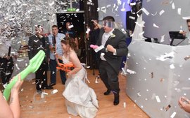 confetti cannon explodes over bride and groom during first dance
